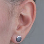 Sterling Silver solid shaped circle earrings, worn in models ear.