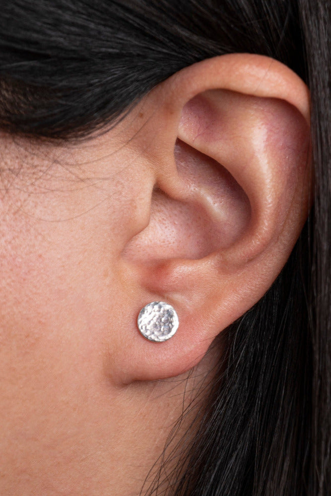 Sterling Silver Round shaped Hammered Textured Earrings worn on models ear lobe