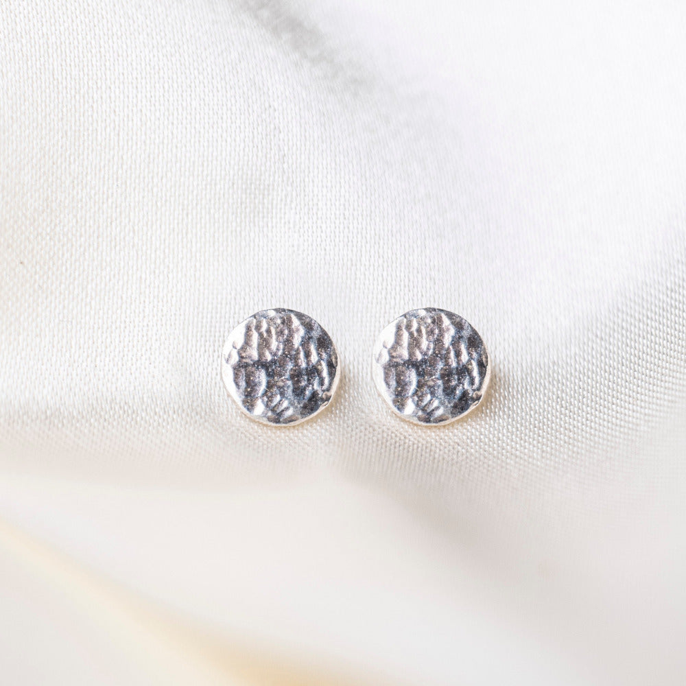 Round Hammered Earrings on silk background