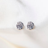 Round Hammered Earrings on silk background