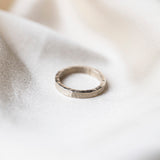 Sterling Silver Hammered textured Ring worn on silk background
