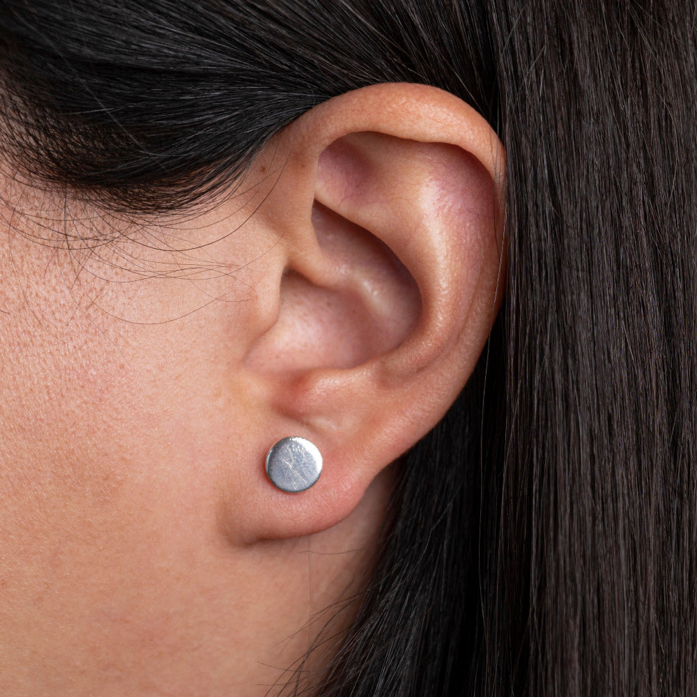 Sterling Silver Coin Earrings worn on models ear lobe