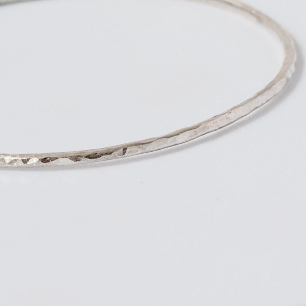 Handmade Hammered Sterling Silver Bracelet (Bangle) close up on white background 