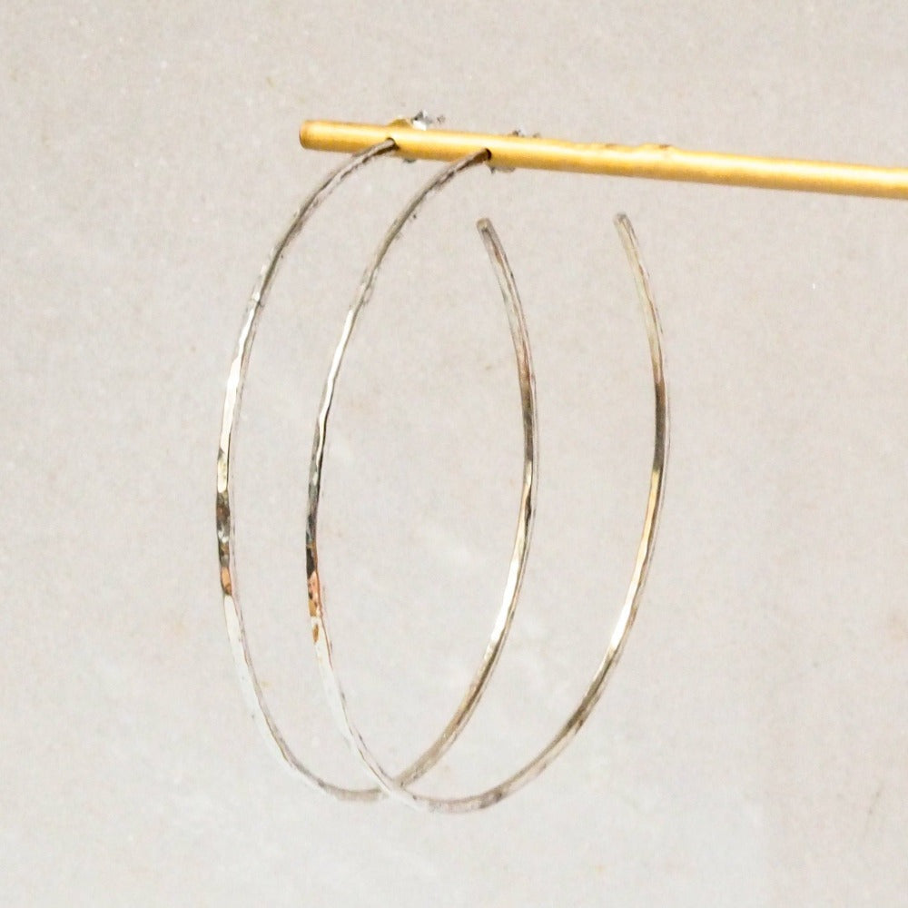 Sterling Silver Hoop Earrings with Hammered Texture Effect displayed on a jewellery stand