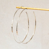 Sterling Silver Hoop Earrings with Hammered Texture Effect displayed on a jewellery stand
