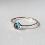 London Blue Topaz Stacking Ring on a cream satin background