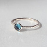 London Blue Topaz Stacking Ring on a cream satin background