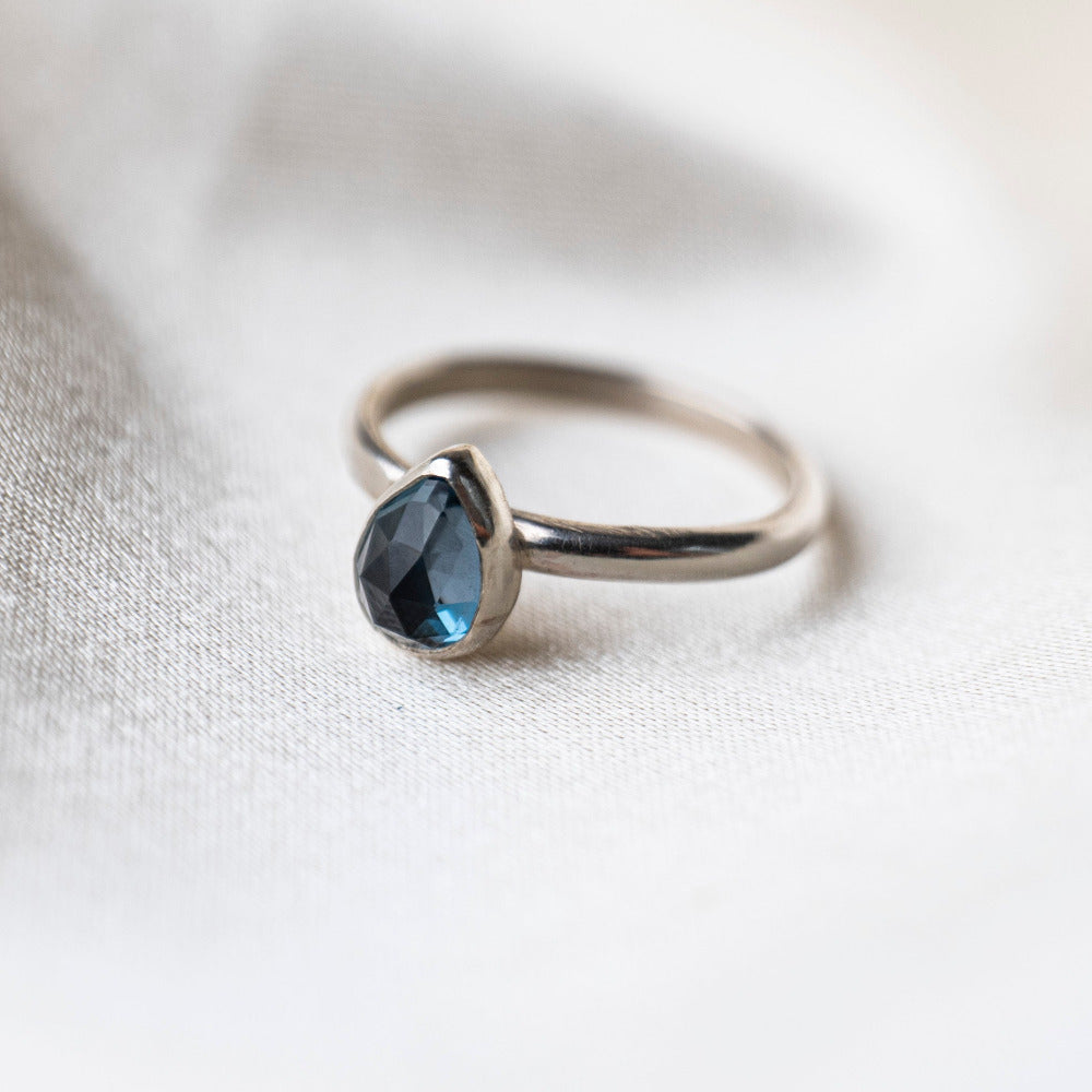 London Blue Topaz Gemstone Prear Sterling Silver Ring on Silk background 