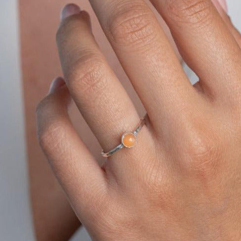 Model wears Peach Moonstone Hammered Sterling Silver Stacking Ring , with a white blouse and frenchtip manicured nails.