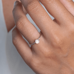 Hand wearing a ring with a Rainbow Moonstone Stacking Ring on a model