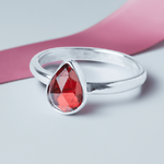 Handmade Sterling Silver Garnet Pear Gemstone Ring on a pink ribbon background
