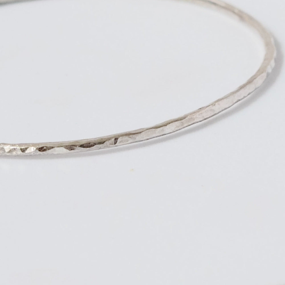 Handmade Hammered Sterling Silver Bangle close up on white background 