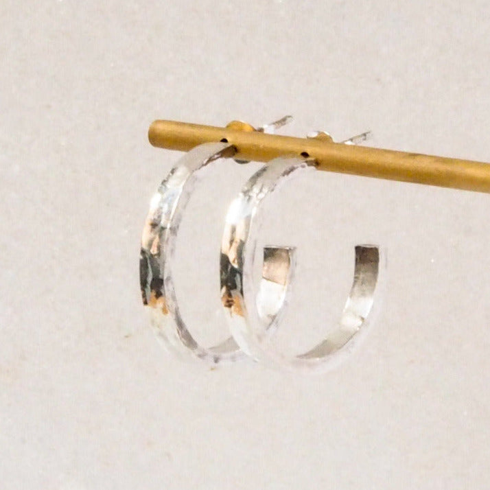 Open Hoop Sterling Silver Earrings with a Hammered Textured, displayed on a marble background.