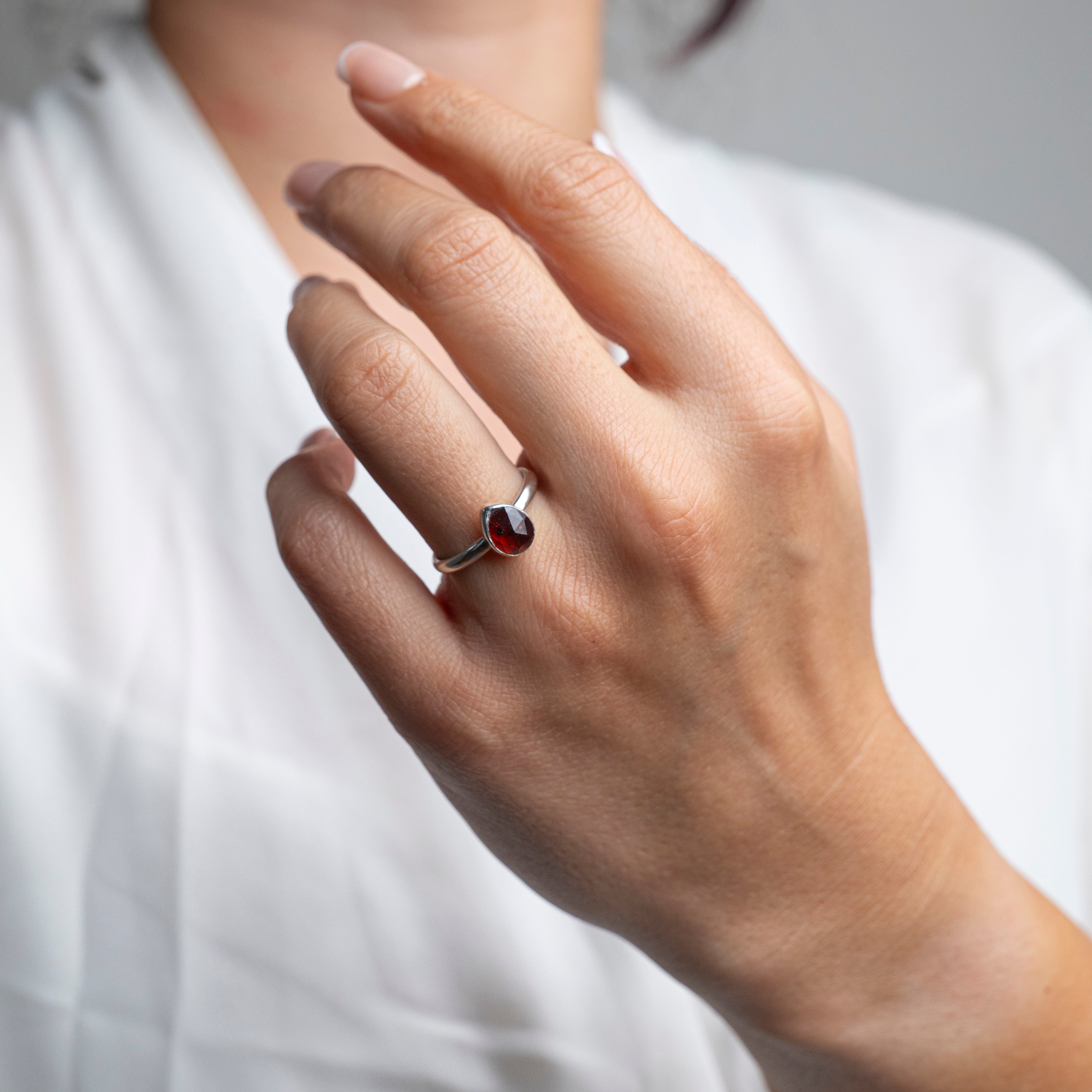 Hand wearing an Ember pear-shaped garnet ring in sterling silver