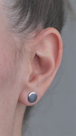 Sterling Silver solid shaped circle earrings, worn in models ear.