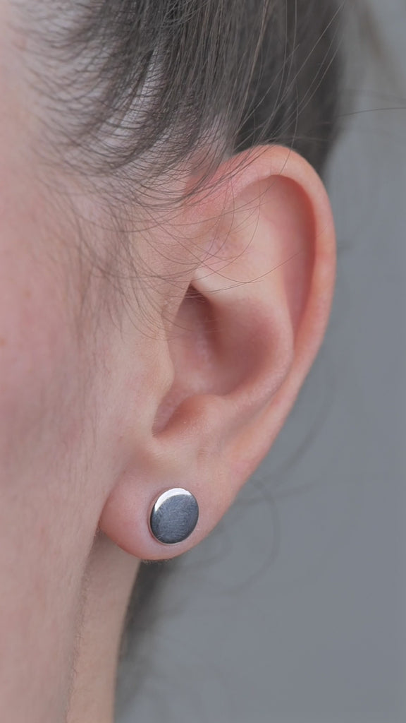 Sterling Silver solid shaped circle earrings, worn in models ear.
