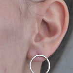 Sterling Silver open circle hammered textured Earrings worn by model in ear. 