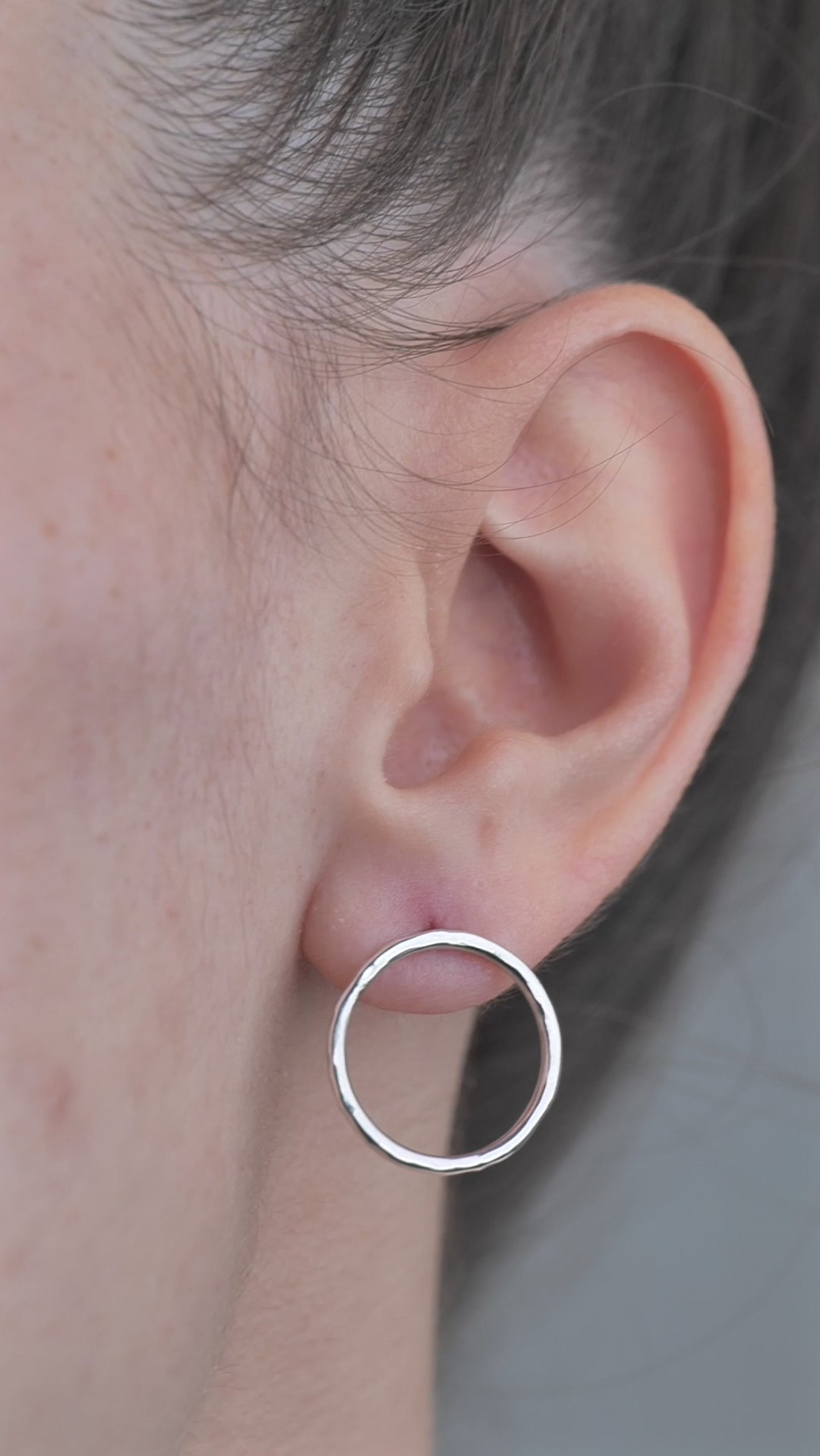 Sterling Silver open circle hammered textured Earrings worn by model in ear. 