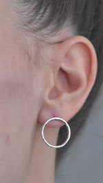 Sterling Silver open circle hammered textured Earrings worn by model in ear. 