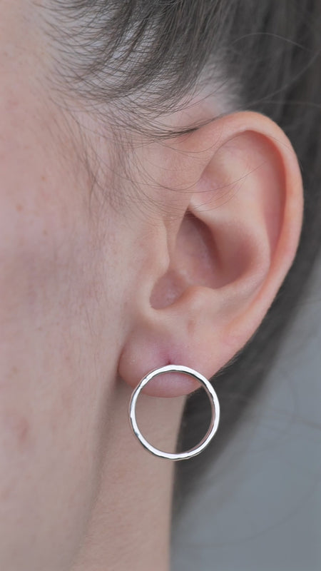 Sterling Silver open circle hammered textured Earrings worn by model in ear. 