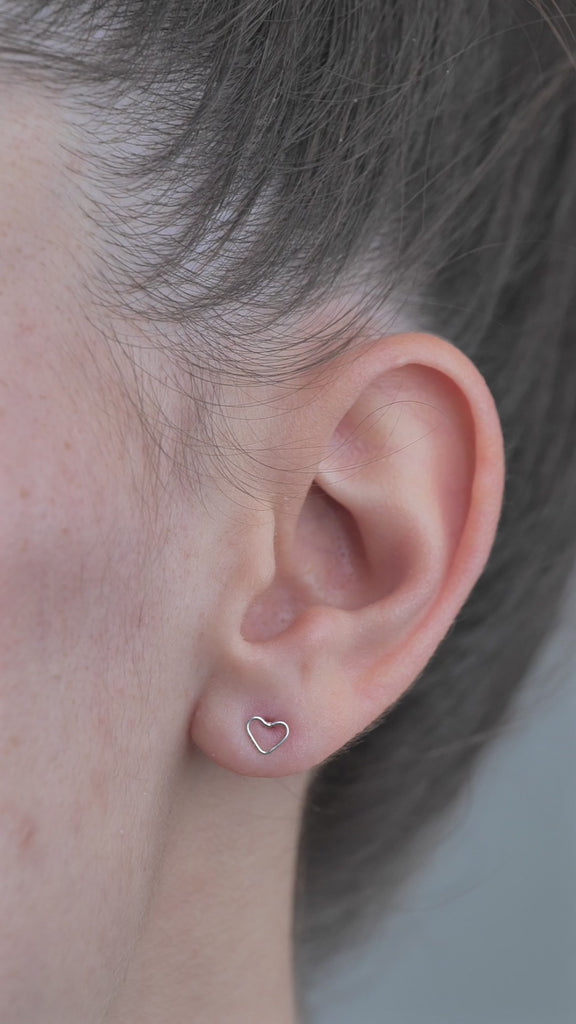 Sterling Silver Mini shaped Heart Earrings worn in models ear.
