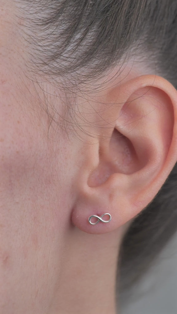 Sterling Silver Infinity shaped Earrings worn in models ear.